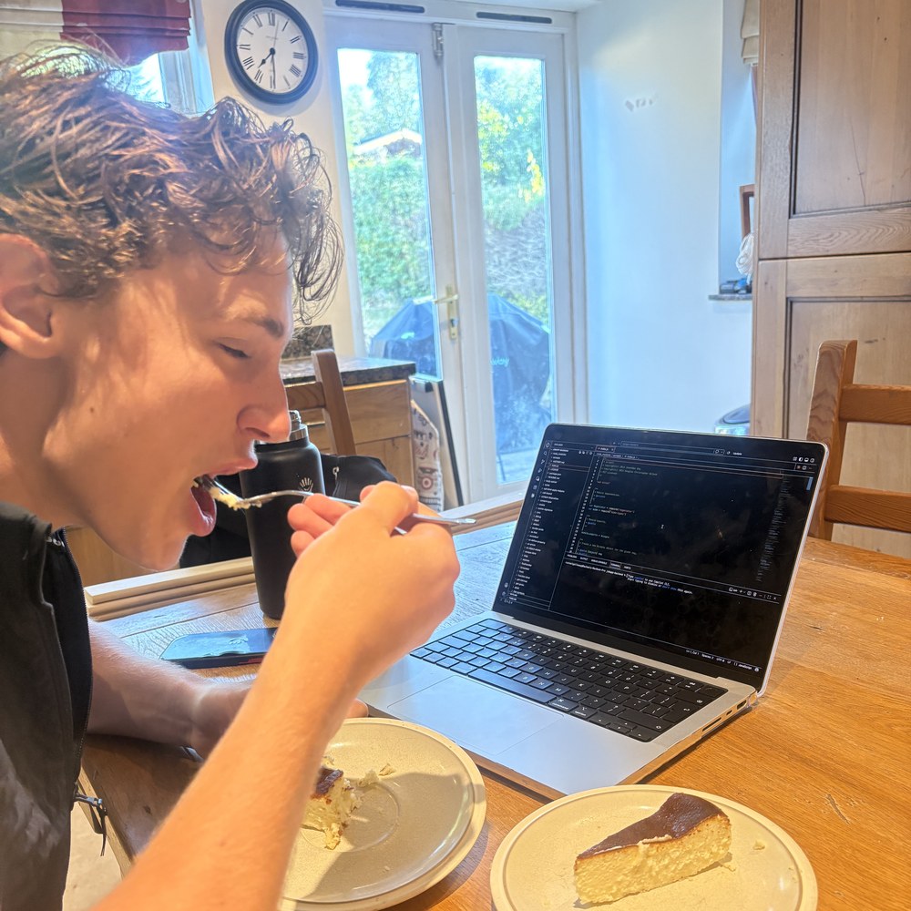 Eating cheesecake at the kitchen table while working on a laptop